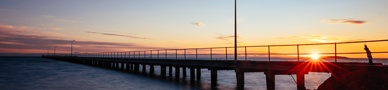 A photograph of a pier at sunset
