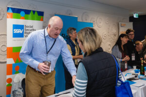 Graeme speaking with a delegate at the SSRv stand at the FCVic Conference