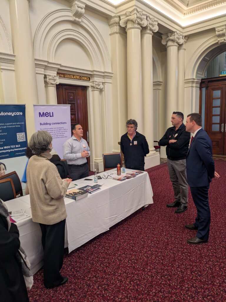 The Hon. Tim Richardson MP speaks with representatives at the Moneycare and MELI exhibition booth