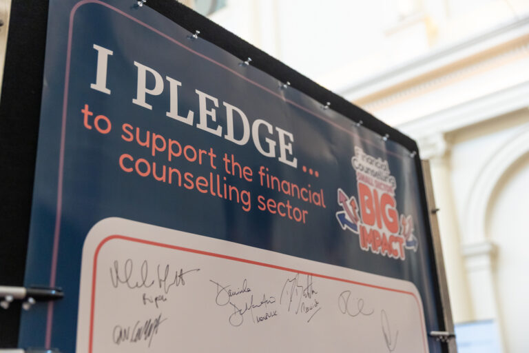 Close-up of the "I pledge to support the financial counselling sector" wall from the Small Sector, Big Impact showcase, with signatures from MPs already added.
