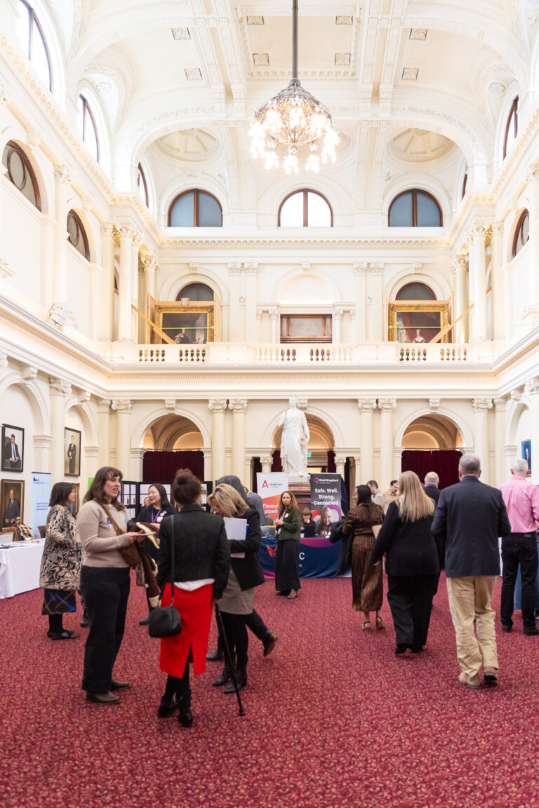 Financial counsellors, agencies and visitors connect beneath Queens Hall's grand chandelier.