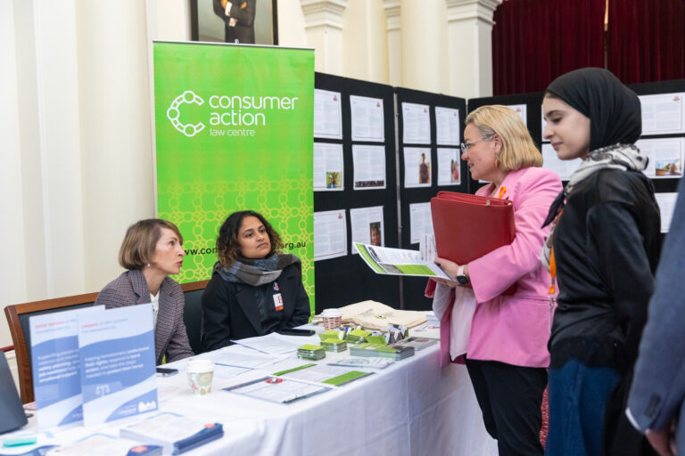 Legislative Assembly member Kathleen Matthews-Ward speaks with Consumer Action Law Centre representatives at their booth.