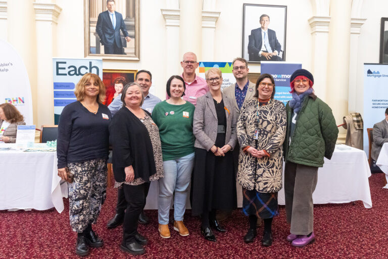 Maree Edwards MP poses with a group of agency representatives in front of the EACH, Social Security Rights Victoria and Knowmore Legal Service booths.