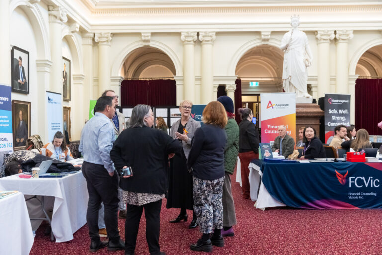 Maree Edwards MP speaks with a group near the FCVic and Anglicare Victoria exhibition booths.