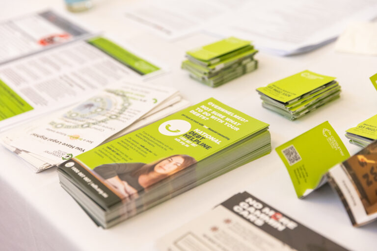 National Debt Helpline and Consumer Action Law Centre brochures spread across an exhibition table.