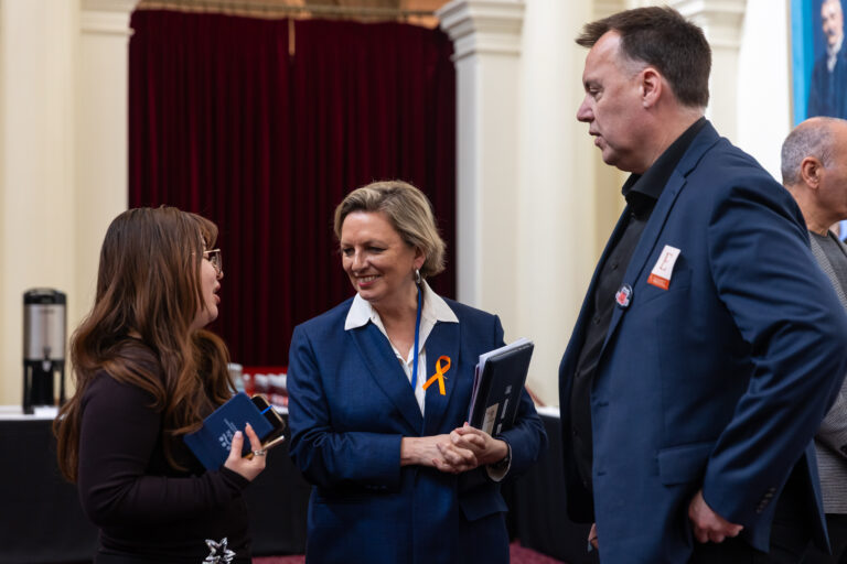 Pauline Richards MP speaks with two attendees in Queens Hall.