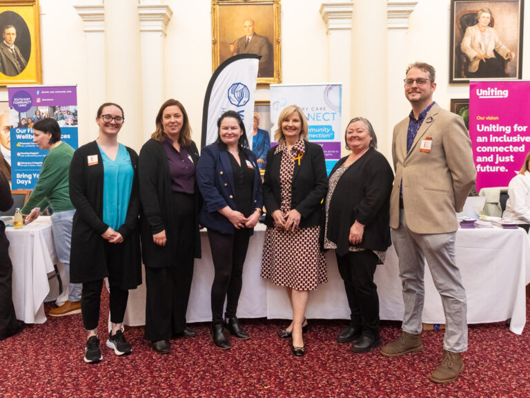 Kim O'Keefe MP poses with five others near the South East Community Links and Uniting booths.