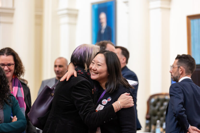 A warm greeting between attendees during the showcase.