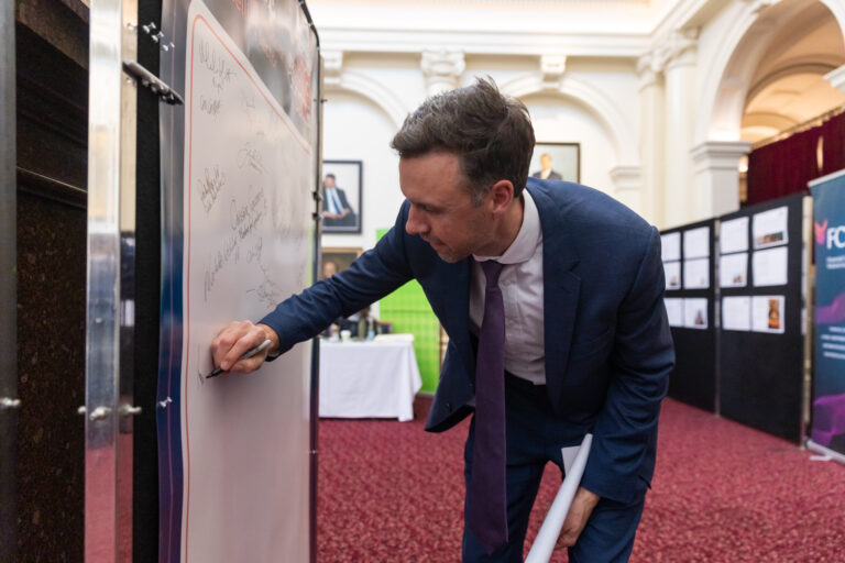 Tom McIntosh MP signs the pledge wall.