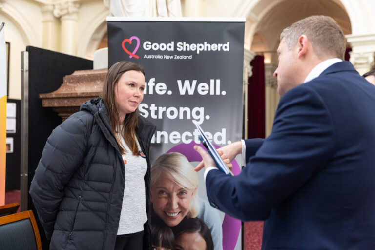 Brad Rowswell MP speaks with an attendee at the Good Shepherd Australia New Zealand exhibition booth.