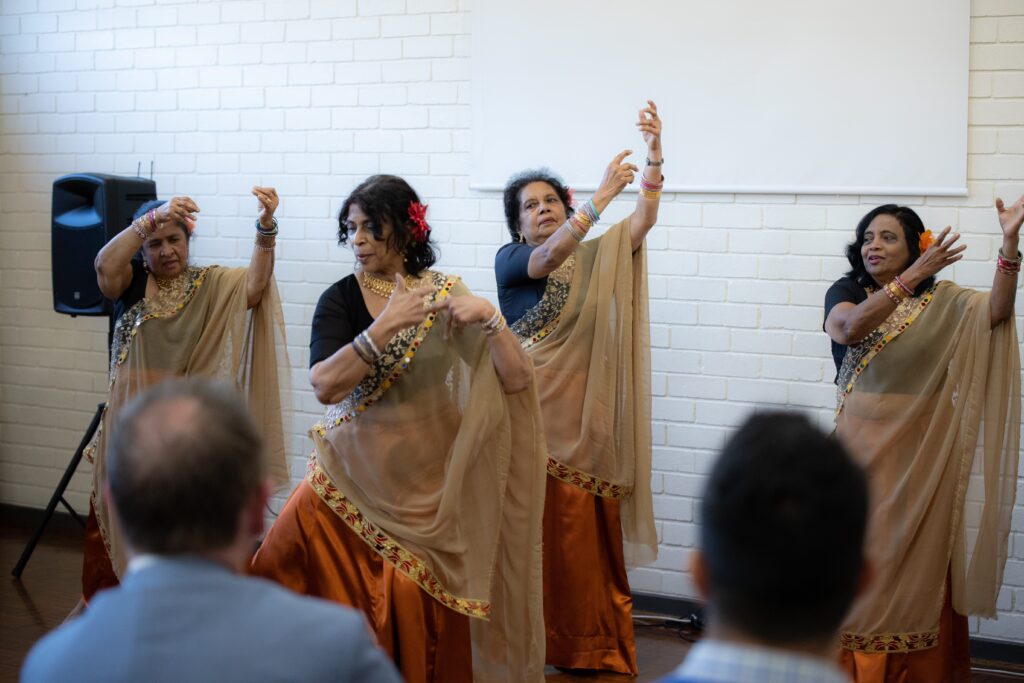 Four women are pictured performing a traditional Sri Lankan dance in front of a crowd