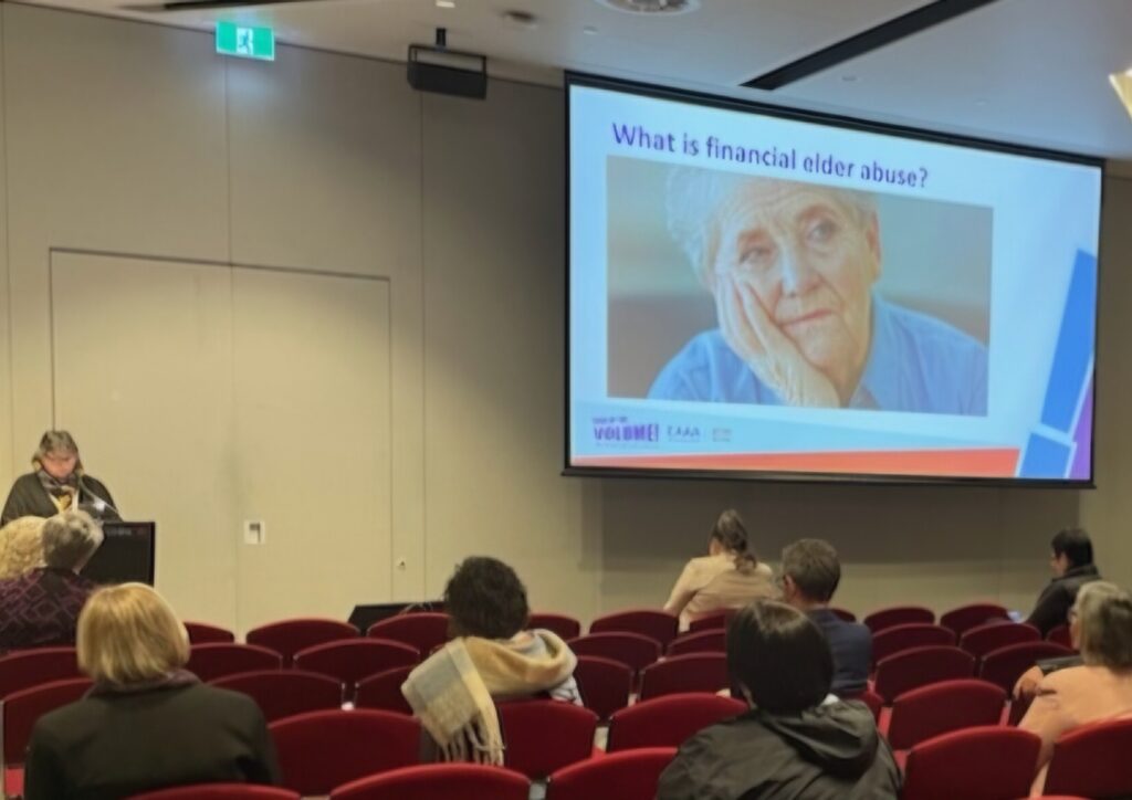 A photograph of attendees listening to Michele
