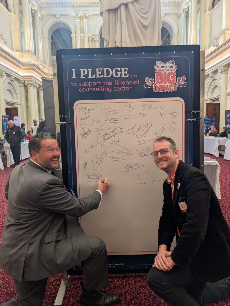 Will Fowles MP signs the "I Pledge" board alongside FCVic's CEO.