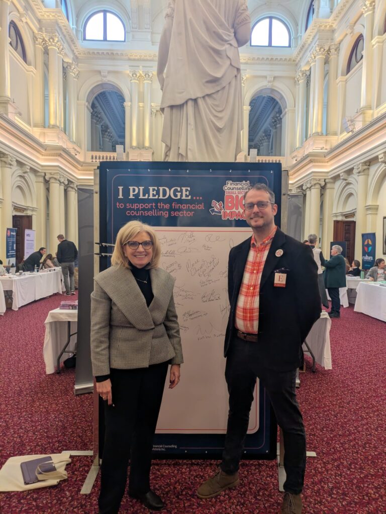 The Hon. Wendy Lovell stands beside FCVic's CEO at the "I Pledge" board in Queen's Hall.
