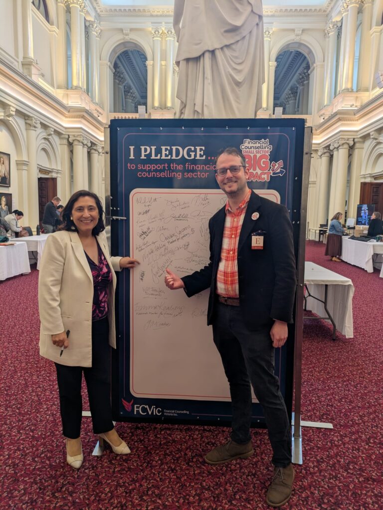 The Hon. Lily D'Ambrosio and FCVic's CEO stand at the "I Pledge" board in Queen's Hall.