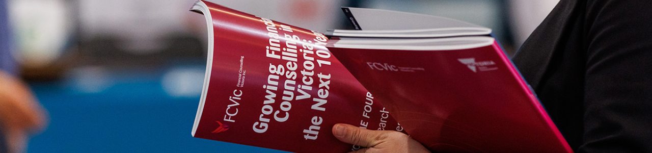 a close up image of a person reading one of the Growing Financial Counselling in Victoria reports